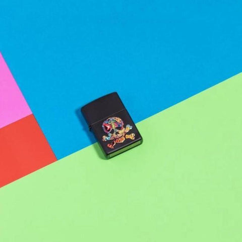 Lifestyle image of Texture Skull Design Windproof Lighter laying flat on neon colored background