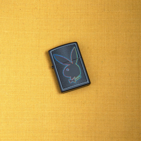 Lifestyle image of Playboy Logo Black Matte Lighter laying on yellow background