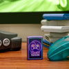 Lifestyle image of Gamer Design Purple Matte windproof lighter standing in front of Nintendo N64 system and gaming controller