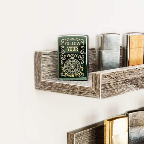 Lifestyle image of Follow Your Way Design High Polish Green Windproof Lighter standing on a shelf with a collection of Zippo lighters