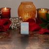 Lifestyle image of Heart Design Satin Chrome Windproof Lighter standing on a table with lit candles and red roses.