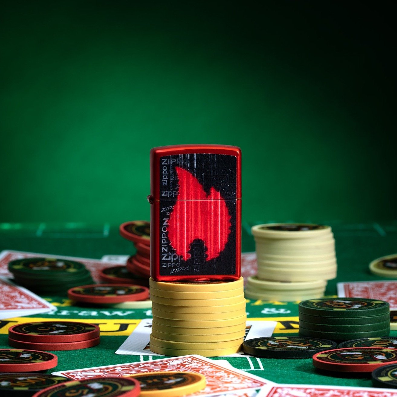 Zippo Flame Logo Design Metallic Red Windproof Lighter standing on stacked poker chips, with cards and chips scattered all around a poker table.