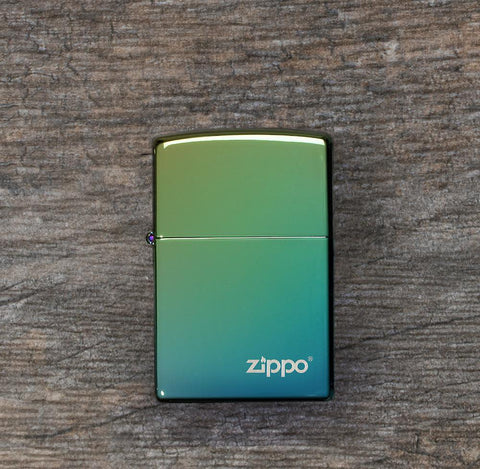Lifestyle image of High Polish Teal Zippo Logo Windproof Lighter laying flat on a wooden surface