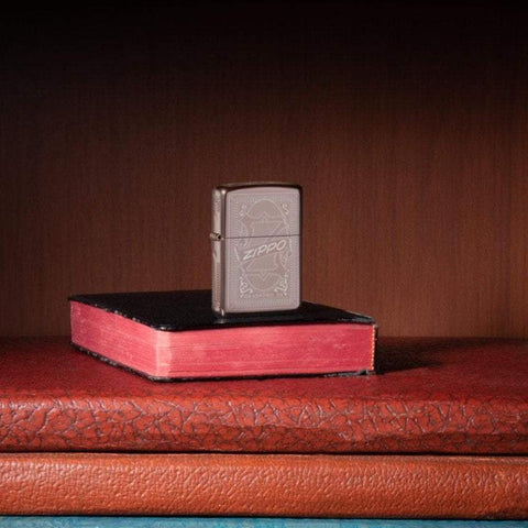 Lifestyle image of Reimagine Zippo High Polish Rose Gold Windproof Lighter, standing in a book case on books