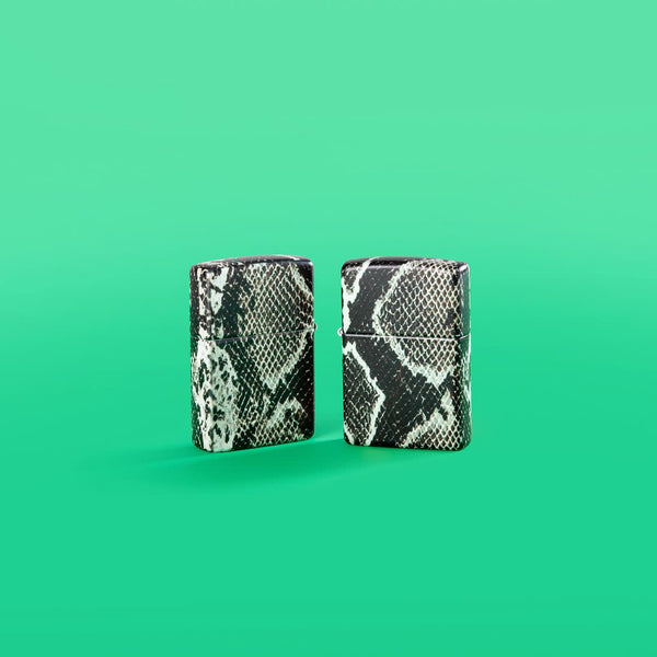 Lifestyle image of Snake Skin Design 540 Color Windproof Lighters standing in a green background.