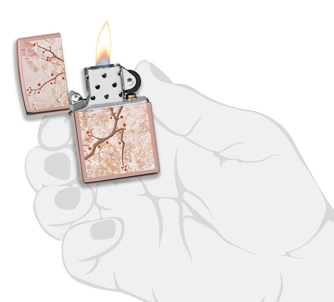 Eastern Design Cherry Blossom High Polish Rose Gold Windproof Lighter lit in hand.