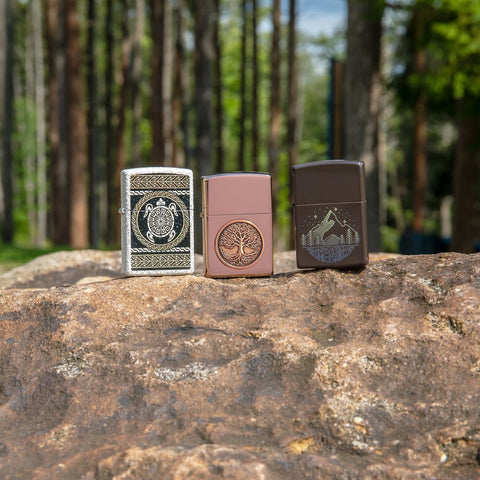 Lifestyle image of Turtle Design Mercury Glass Windproof Lighter outside, standing on a rock with two other lighters.