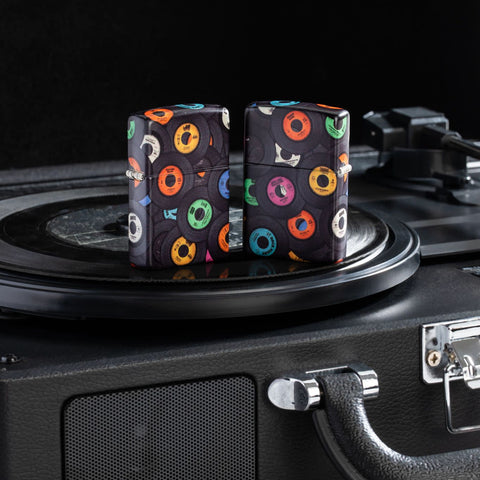Lifestyle image of two Zippo Records Design 540 Matte Windproof Lighters sitting on a record player.